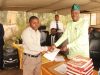 Dr. Adeniran presenting promotion letters to a teacher