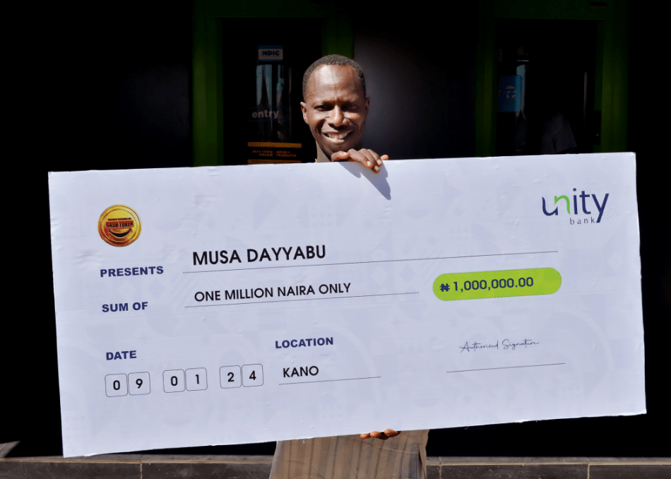 The winner, Mr. Musa Dayyabu poses with his cheque after presentation.